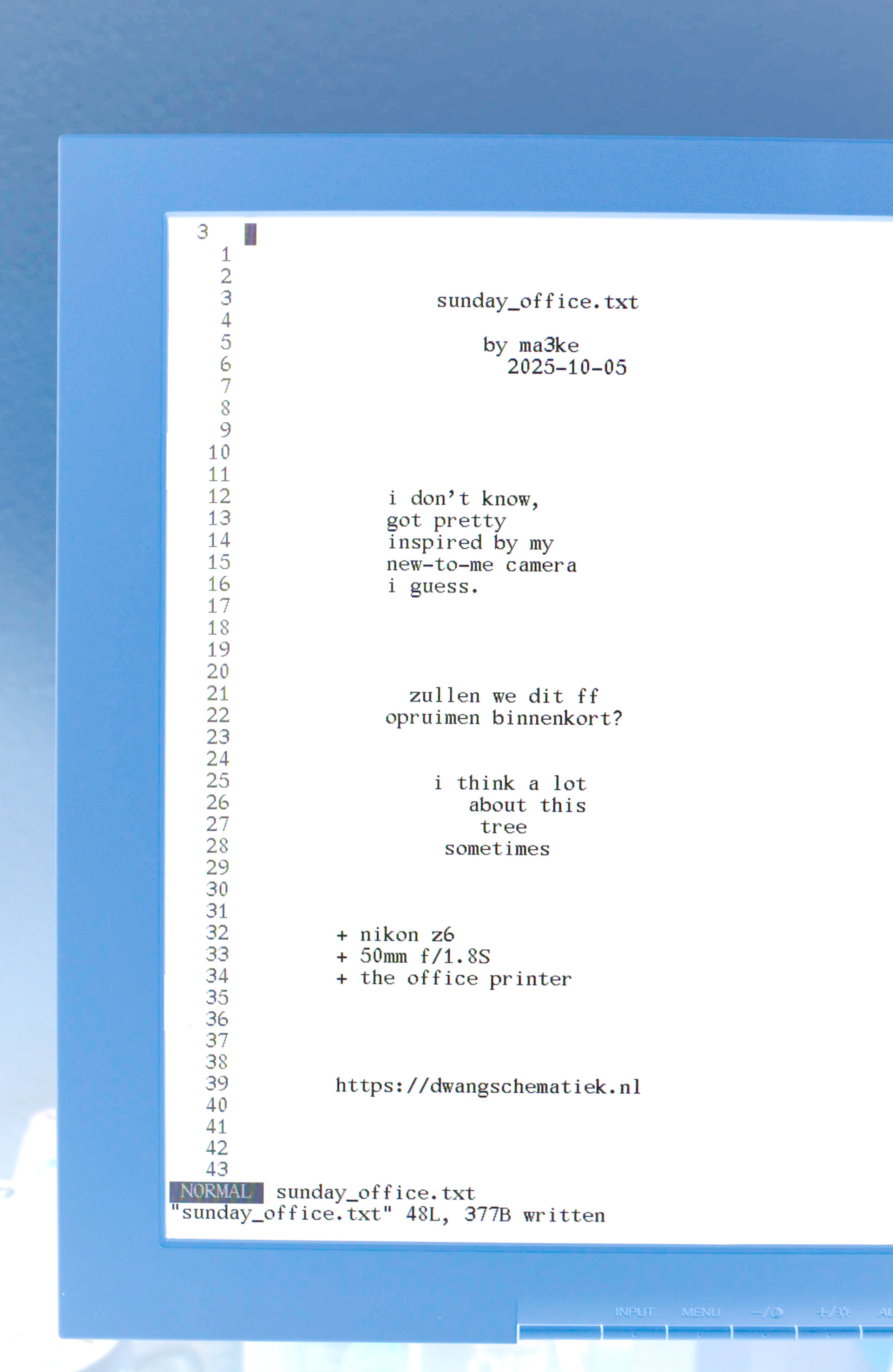 An inverted photo of a computer screen with a text editor opened in a tty. The colors of the monitor rim and wall behind it are a pleasant powder blue, and the text is black on white.